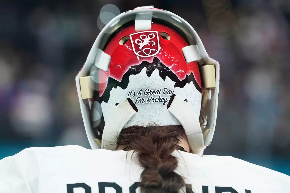 Switzerland's Andrea Braendli (20) sports a message on her helmet during a women's ice hockey bronze medal game between Switzerland and Sweden at the 2026 Winter Olympics, in Milan, Italy, Thursday, Feb. 19, 2026. (AP Photo/Petr David Josek)