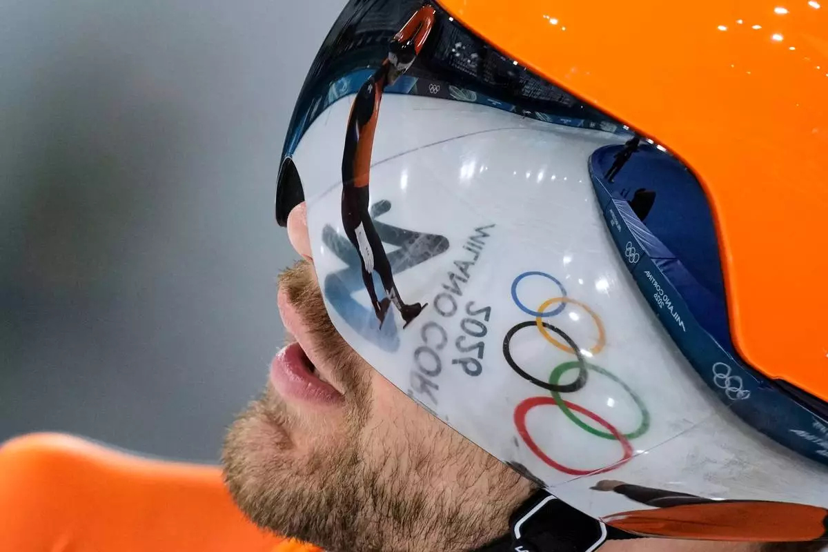 The Olympic Rings are reflected in the vizor of the helmet of Chris Huizinga of the Netherlands ahead of the men's team pursuit quarterfinals speedskating race at the 2026 Winter Olympics, in Milan, Italy, Sunday, Feb. 15, 2026. (AP Photo/Luca Bruno)