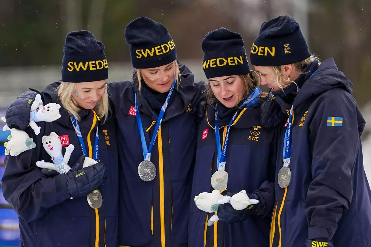 Jonna Sundling, Frida Karlsson, Ebba Andersson, and Linn Svahn, of Sweden, stands on the podium after winning the silver medal in the cross country skiing women's 4 x 7.5km relay at the 2026 Winter Olympics, in Tesero, Italy, Saturday, Feb. 14, 2026. (AP Photo/Matthias Schrader)
