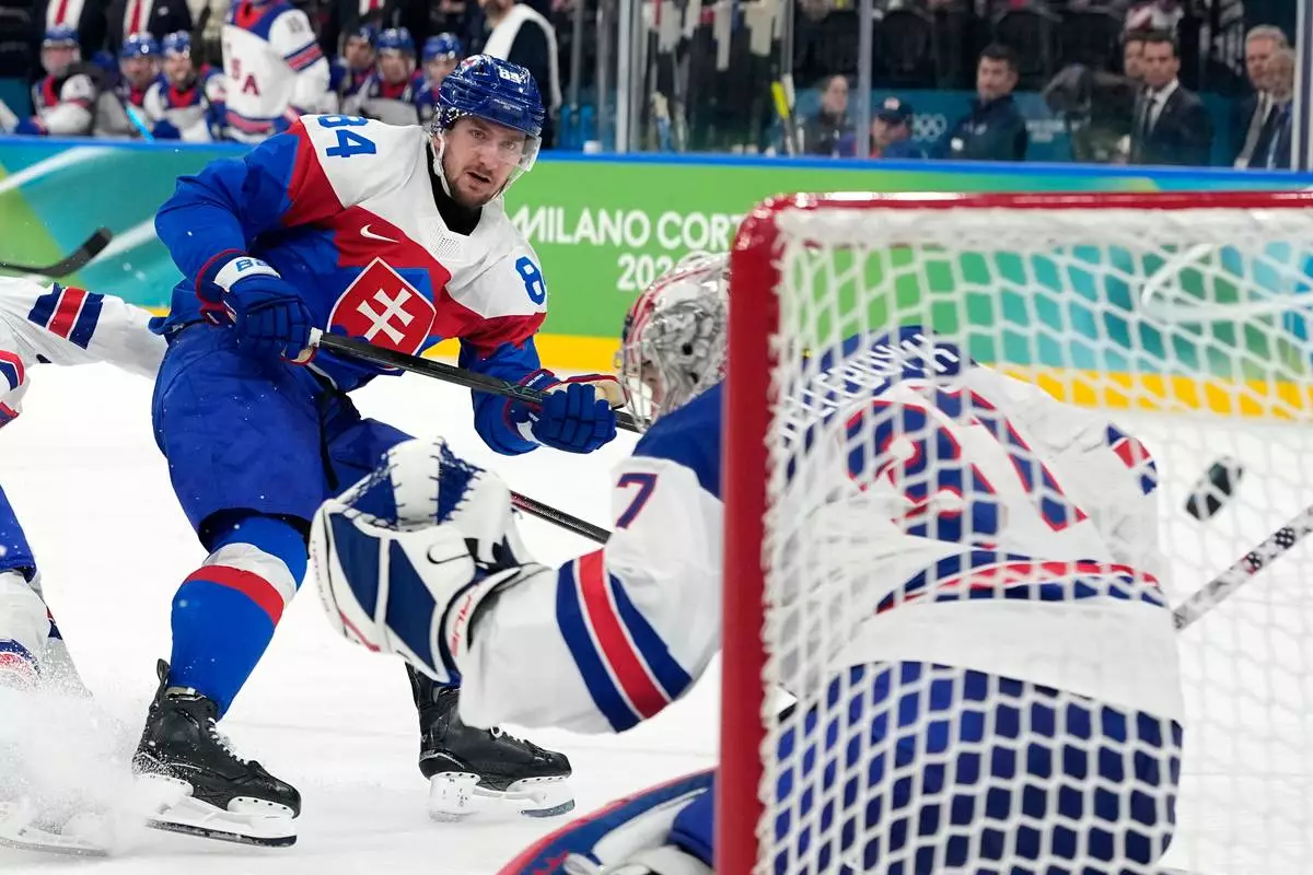 Slovakia's Pavol Regenda (84) scores his side's second goal during a men's ice hockey semifinal game between the United States and Slovakia at the 2026 Winter Olympics, in Milan, Italy, Friday, Feb. 20, 2026. (AP Photo/Hassan Ammar)
