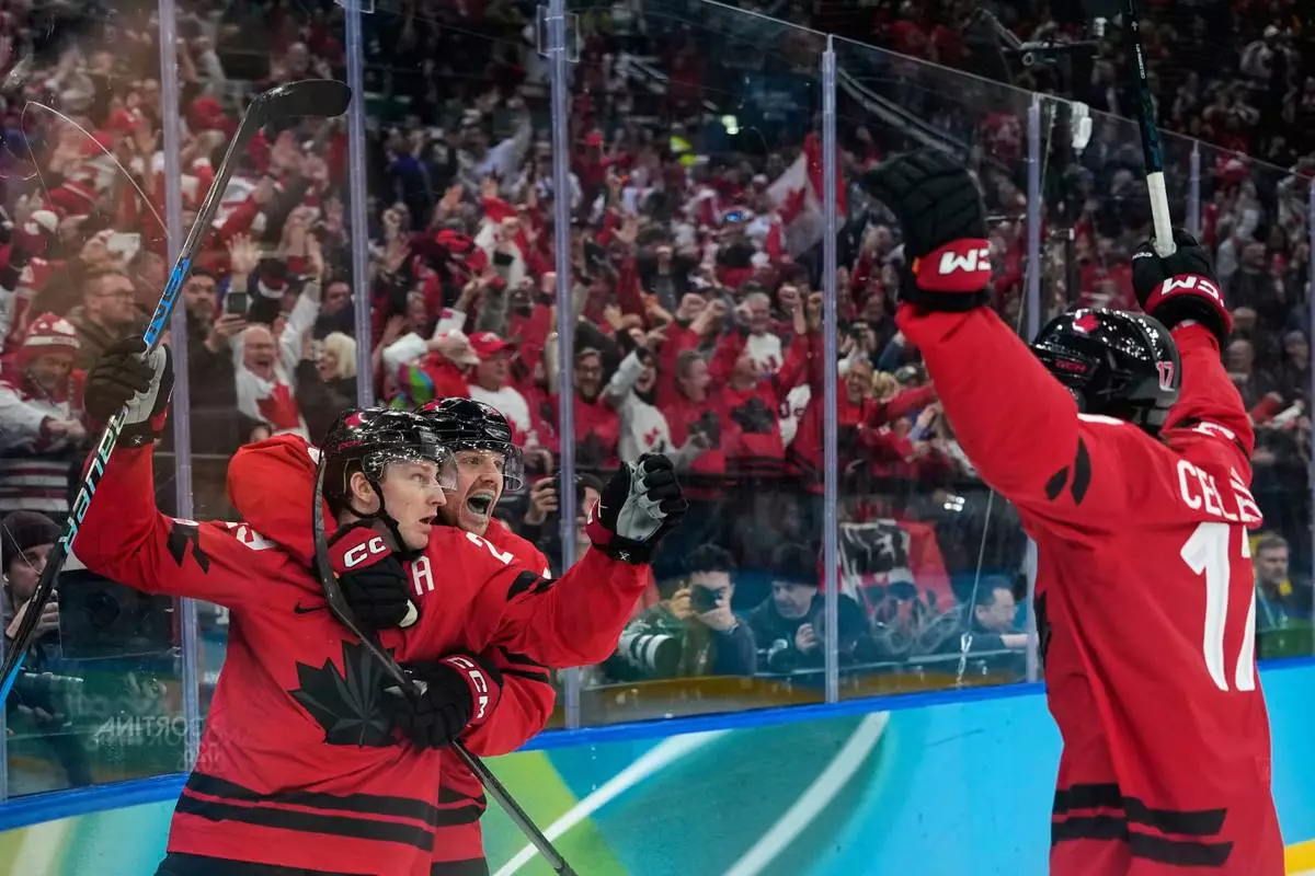 Canada's Nathan MacKinnon (29) celebrates with teammates after scoring his side's third goal during a men's ice hockey semifinal game between Canada and Finland at the 2026 Winter Olympics, in Milan, Italy, Friday, Feb. 20, 2026. (AP Photo/Petr David Josek)