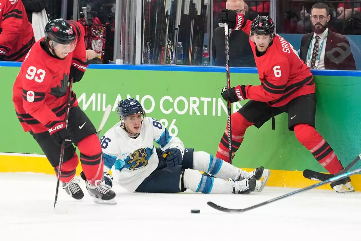 Finland's Teuvo Teravainen (86) challenges with Canada's Travis Sanheim (6) and Canada's Mitch Marner (93) during a men's ice hockey semifinal game between Canada and Finland at the 2026 Winter Olympics, in Milan, Italy, Friday, Feb. 20, 2026. (AP Photo/Hassan Ammar)