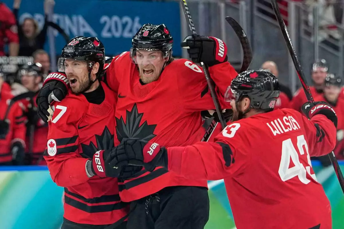 Canada's Shea Theodore (27) celebrates with teammates after scoring his side's second goal during a men's ice hockey semifinal game between Canada and Finland at the 2026 Winter Olympics, in Milan, Italy, Friday, Feb. 20, 2026. (AP Photo/Petr David Josek)