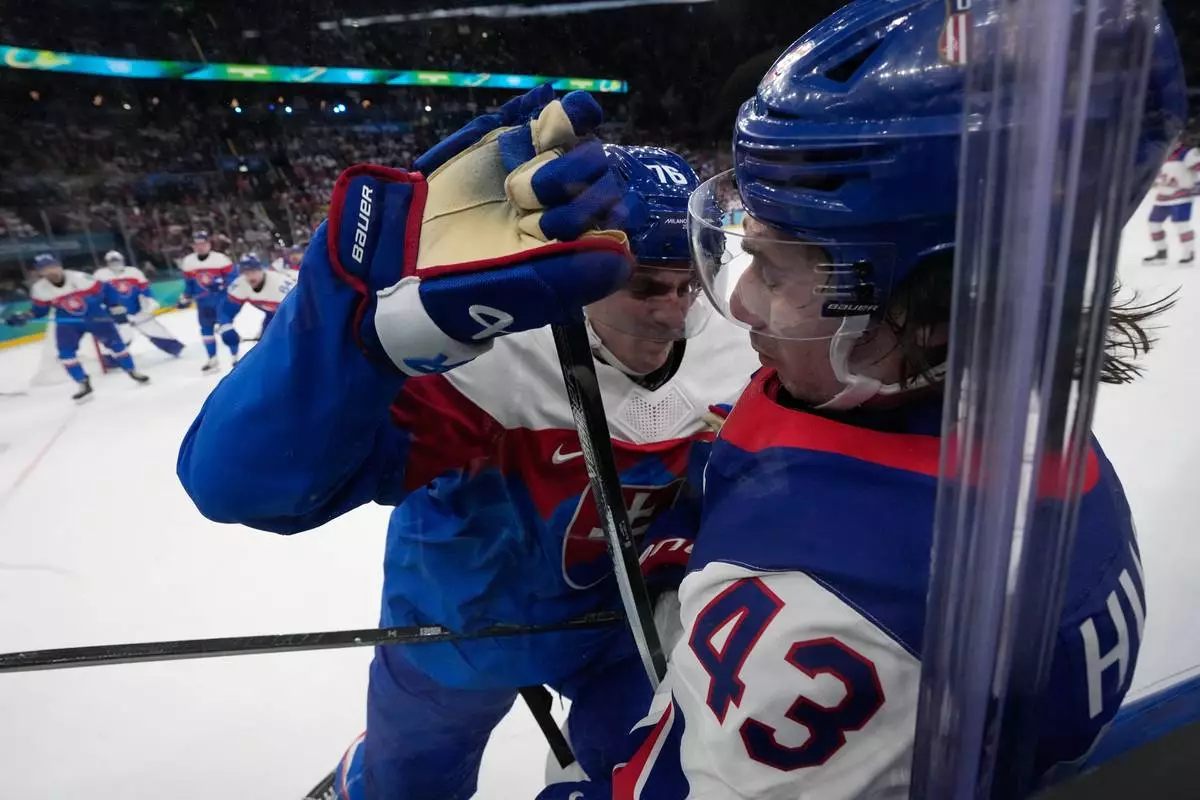 Slovakia's Martin Pospisil (76) scuffles with United States' Quinn Hughes (43) during a men's ice hockey semifinal game between United States and Slovakia at the 2026 Winter Olympics, in Milan, Italy, Friday, Feb. 20, 2026. (AP Photo/Petr David Josek)