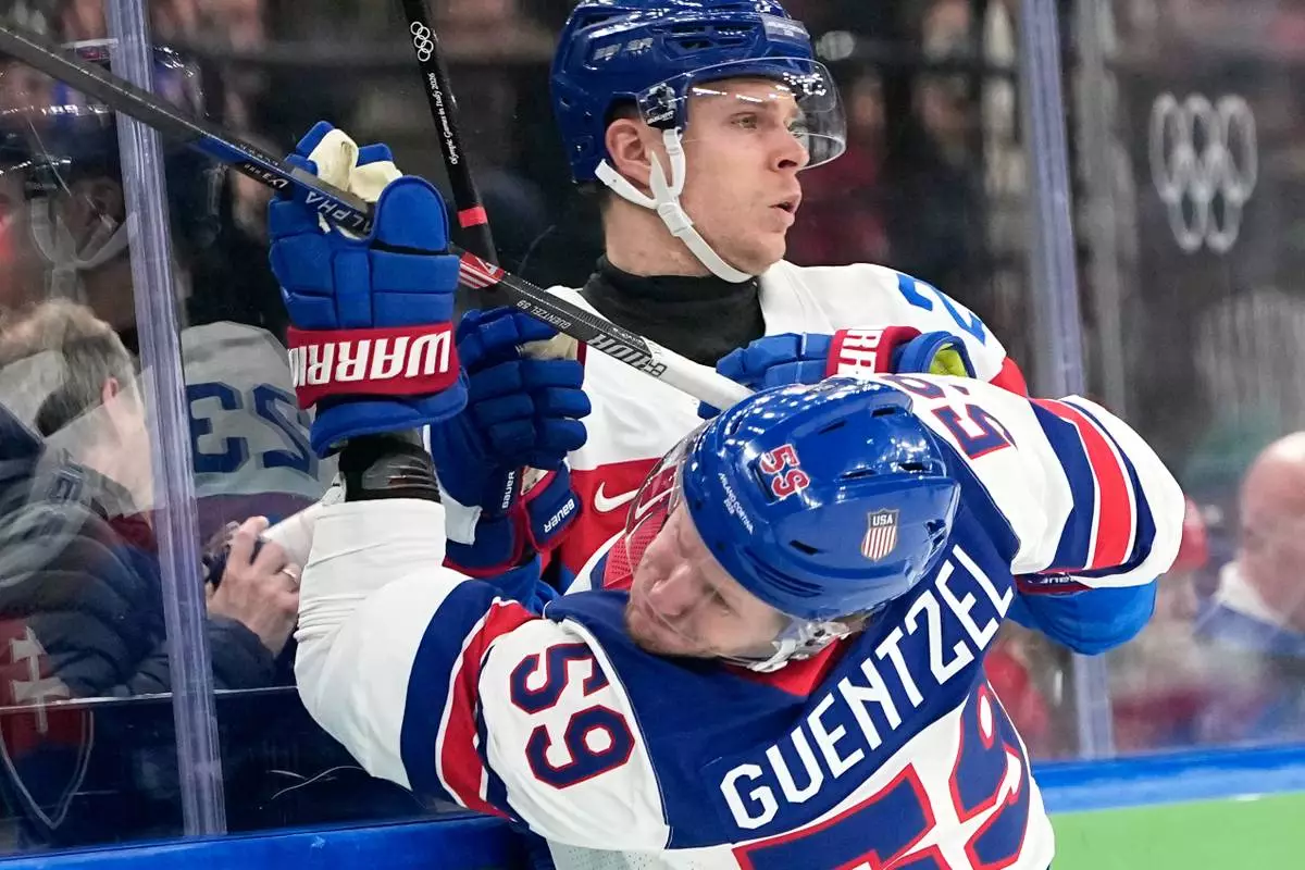 Slovakia's Adam Liska (23) challenges with United States' Jake Guentzel (59) during a men's ice hockey semifinal game between the United States and Slovakia at the 2026 Winter Olympics, in Milan, Italy, Friday, Feb. 20, 2026. (AP Photo/Hassan Ammar)