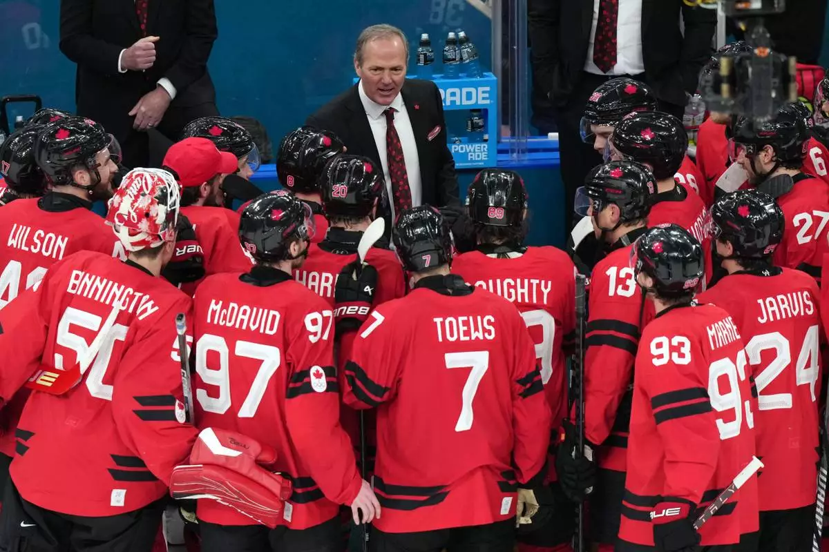 Canada head coach Jon Cooper talks with his players after their win against Finland in a men's ice hockey semifinal game at the 2026 Winter Olympics in Milan, Italy, Friday, Feb. 20, 2026. (AP Photo/Carolyn Kaster)
