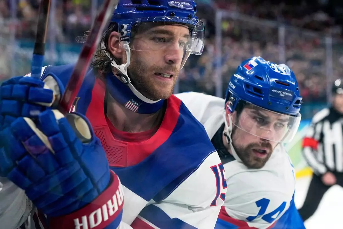 United States' Noah Hanifin (15) challenges with Slovakia's Peter Ceresnak (14) during a men's ice hockey semifinal game between the United States and Slovakia at the 2026 Winter Olympics, in Milan, Italy, Friday, Feb. 20, 2026. (AP Photo/Hassan Ammar)