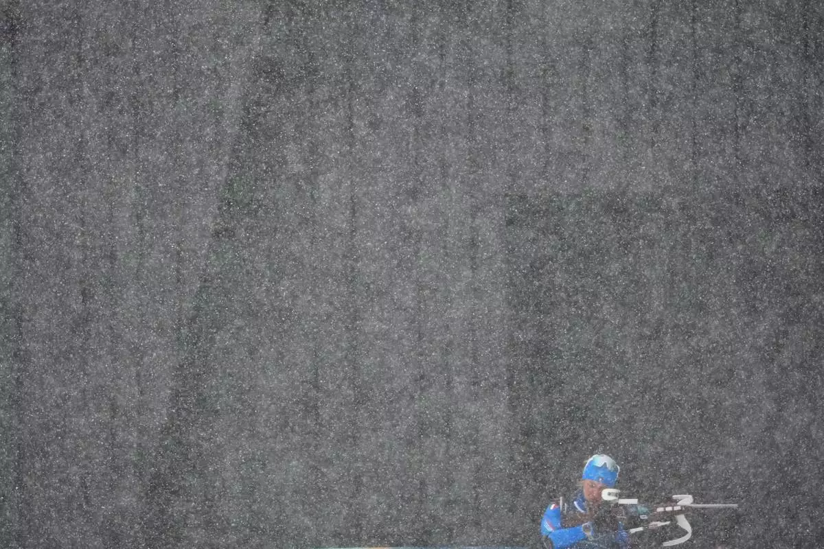 An Italian athlete trains before the men's 4 x 7.5km biathlon relay as heavy snow falls at the 2026 Winter Olympics, in Anterselva, Italy, Tuesday, Feb. 17, 2026. (AP Photo/Christophe Ena)