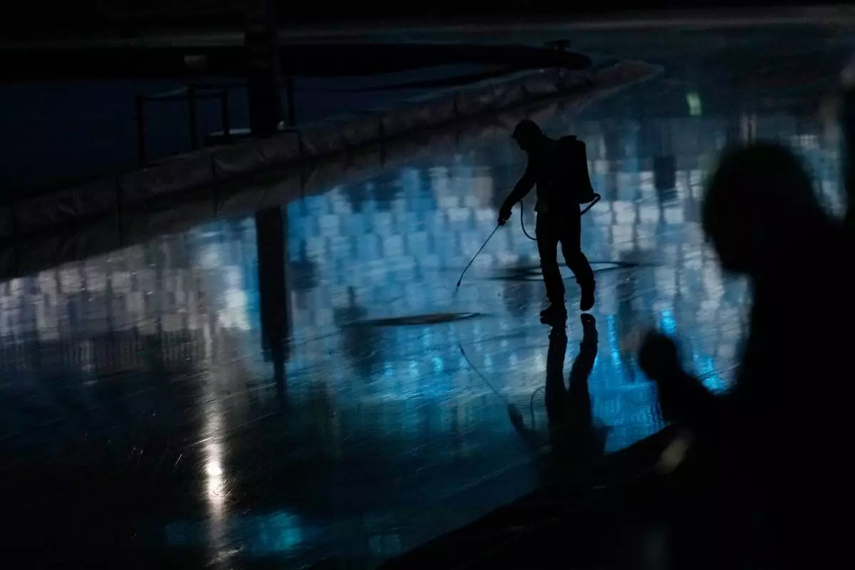 Cracks in the ice are being repaired ahead of team pursuit speedskating races at the 2026 Winter Olympics, in Milan, Italy, Tuesday, Feb. 17, 2026. (AP Photo/Luca Bruno)