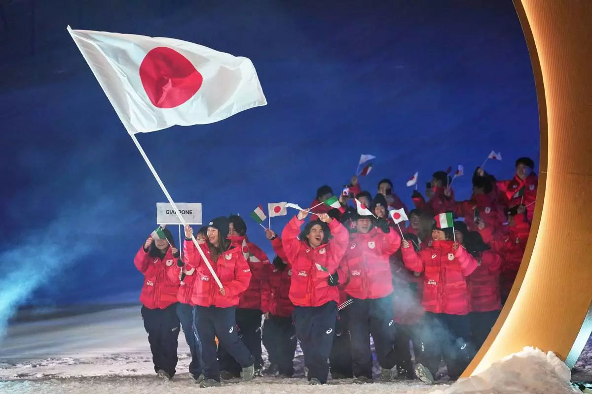 Sena Tomita, flag bearer of Japan, walks with athletes during the Olympic opening ceremony at the 2026 Winter Olympics, in Livigno, Italy, Friday, Feb. 6, 2026. (AP Photo/Abbie Parr)