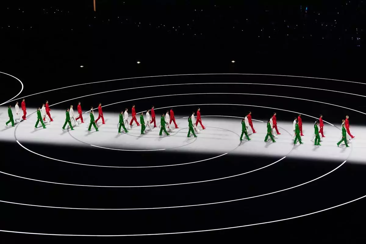 Artists wearing Italian colors perform during the Olympic opening ceremony at the 2026 Winter Olympics, in Milan, Italy, Friday, Feb. 6, 2026. (AP Photo/Petr David Josek)