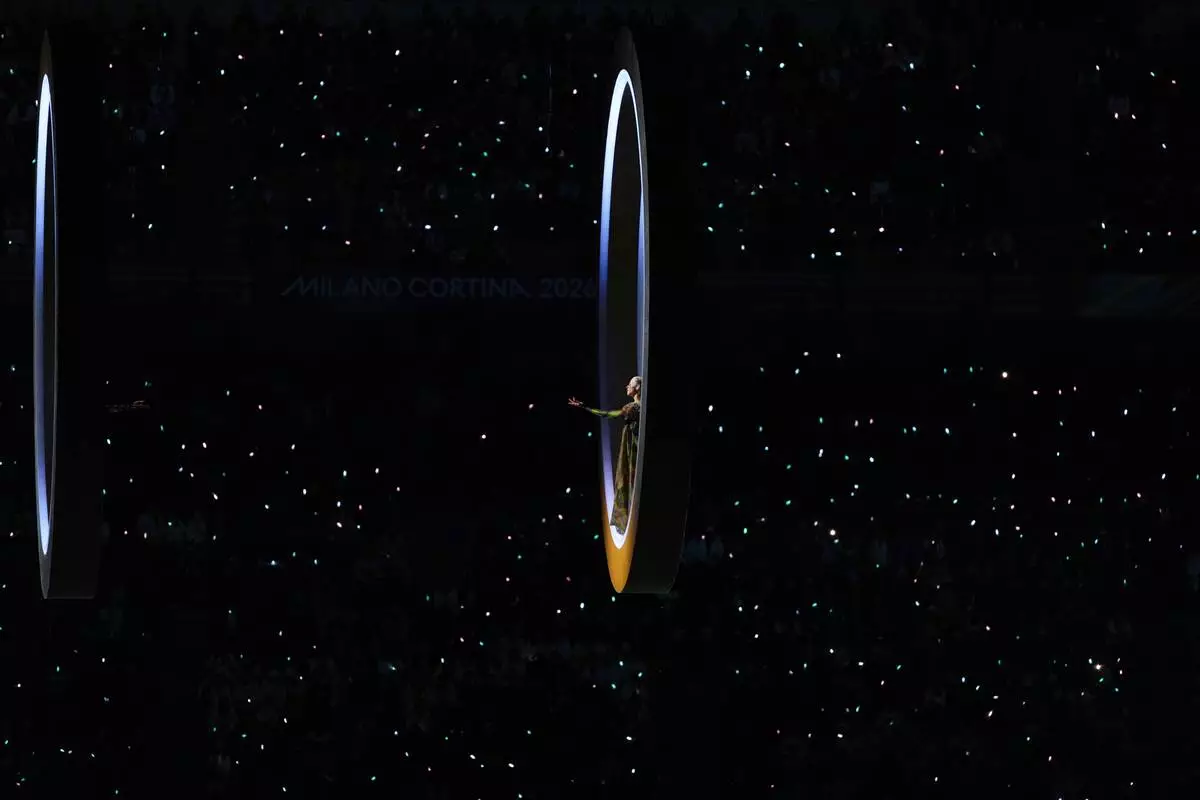 An artist performs as the Olympic rings come together during the Olympic opening ceremony at the 2026 Winter Olympics, in Milan, Italy, Friday, Feb. 6, 2026. (AP Photo/Francisco Seco)