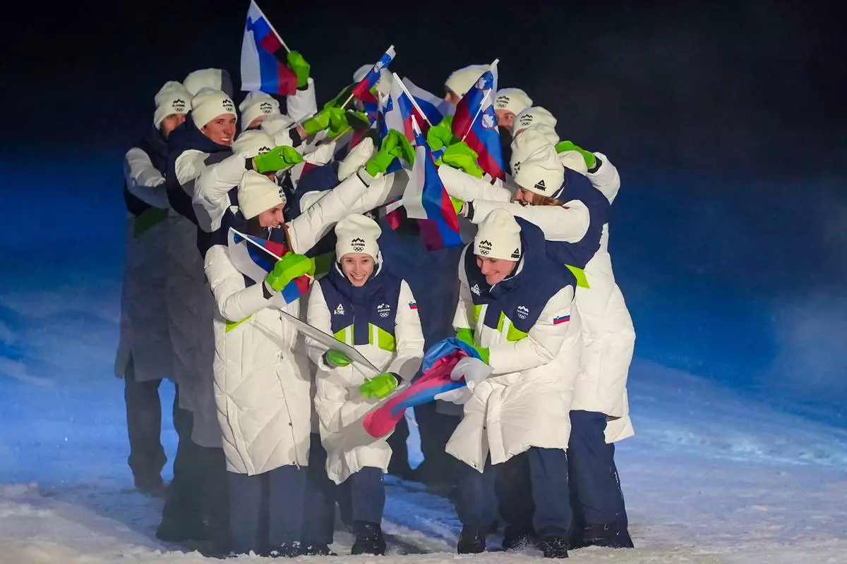 Nika Prevc and Domen Prevc, the flag bearers of Slovenia, take part in the athletes parade during the Olympic opening ceremony at the 2026 Winter Olympics, in Predazzo, Italy, Friday, Feb. 6, 2026. (AP Photo/Kirsty Wigglesworth)