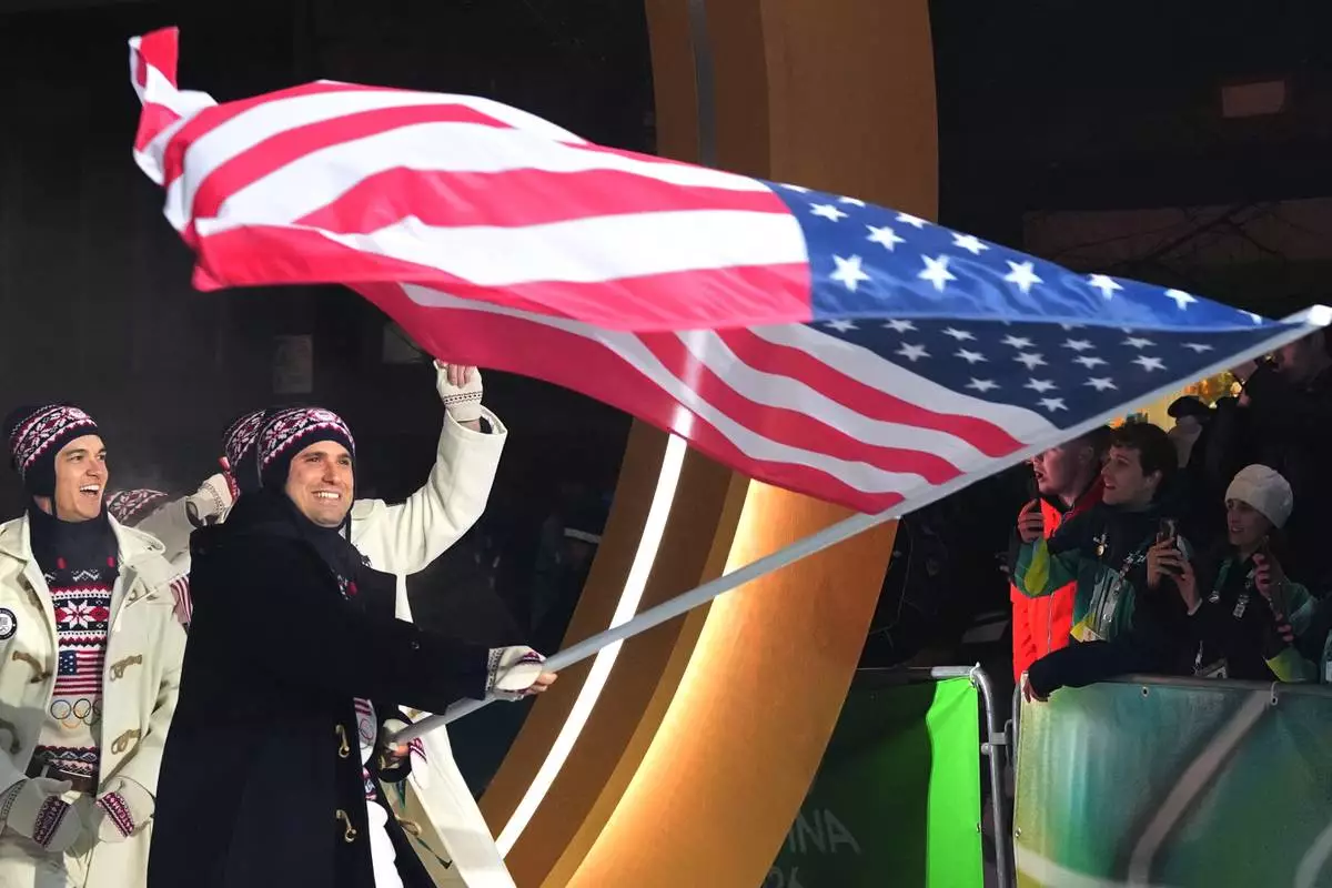 Frankie del Duca, flag bearer of United States, leads his team in during the Olympic opening ceremony at the 2026 Winter Olympics, in Cortina d'Ampezzo, Italy, Friday, Feb. 6, 2026. (AP Photo/Misper Apawu)
