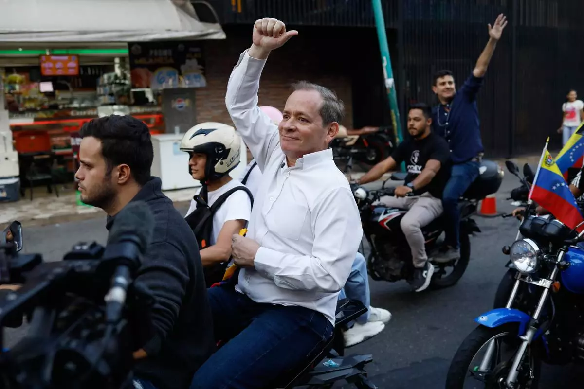 Opposition leader Juan Pablo Guanipa rides on the back of a motorcycle after his release from prison in Caracas, Venezuela, Sunday, Feb. 8, 2026. (AP Photo/Cristian Hernandez)