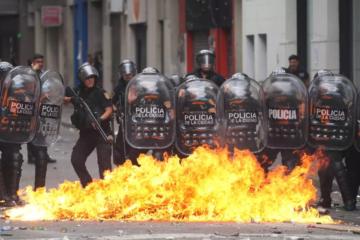 A Molotov cocktail bursts into flames in front of police during a march by unions and opposition supporters against a labor reform bill proposed by President Javier Milei's government in Buenos Aires, Argentina, Wednesday, Feb. 11, 2026.(AP Photo/Rodrigo Abd)