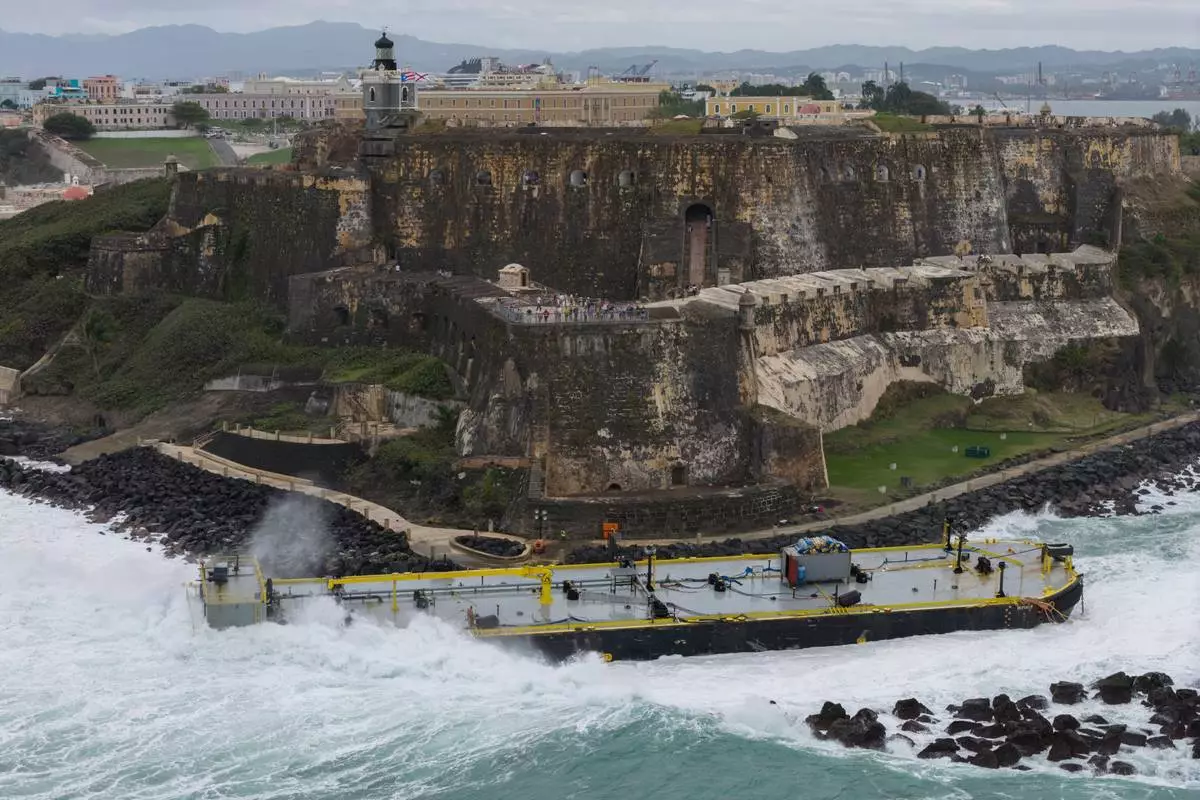 A fuel barge sits grounded near the Castillo San Felipe del Morro by San Juan Bay in San Juan, Puerto Rico, Tuesday, Feb. 10, 2026. (AP Photo/Alejandro Granadillo)