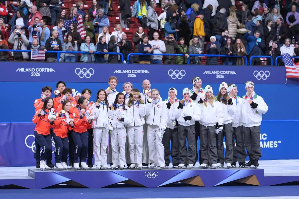 From left to right, silver medalists Team Japan, gold medalists Team USA and bronze medalists Team Italy receive their medals after the figure skating team event at the 2026 Winter Olympics, in Milan, Italy, Sunday, Feb. 8, 2026. (AP Photo/Stephanie Scarbrough)