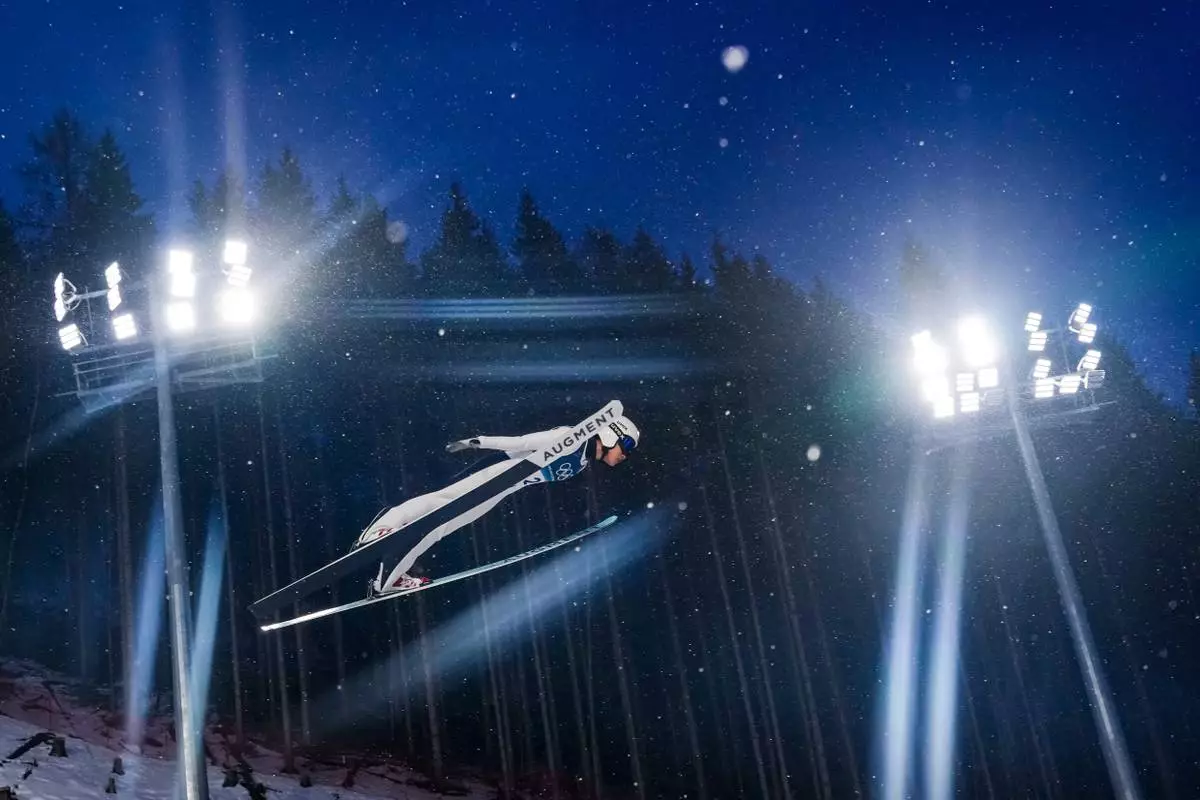 Song Qiwu, of China, soars through the air during the ski jumping men's large hill individual at the 2026 Winter Olympics, in Predazzo, Italy, Saturday, Feb. 14, 2026. (AP Photo/Kirsty Wigglesworth)