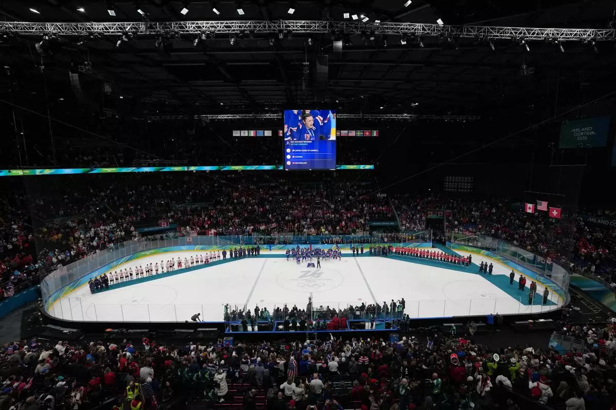 Teams from the United States, Canada and Switzerland receive their medals following the women's ice hockey gold medal game at the 2026 Winter Olympics, in Milan, Italy, Thursday, Feb. 19, 2026. (AP Photo/Carolyn Kaster)