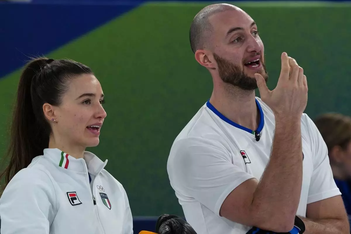 Italy's Amos Mosaner and Stefania Constantini strategize during the mixed doubles round robin phase of the curling competition against Sweden, at the 2026 Winter Olympics, in Cortina d'Ampezzo, Italy, Saturday, Feb. 7, 2026. (AP Photo/Misper Apawu)