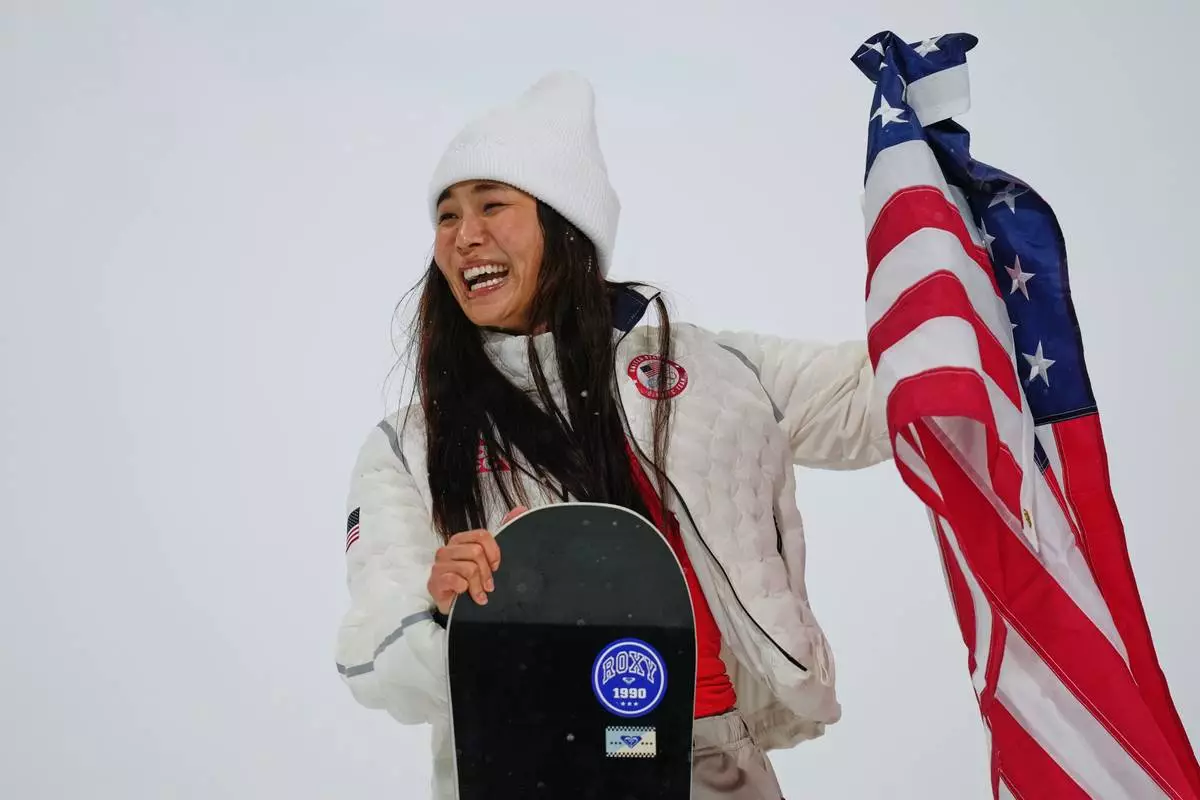 Silver medalist United States' Chloe Kim laughs while trying to display the American flag competes after the women's snowboarding halfpipe finals at the 2026 Winter Olympics, in Livigno, Italy, Thursday, Feb. 12, 2026. (AP Photo/Abbie Parr)