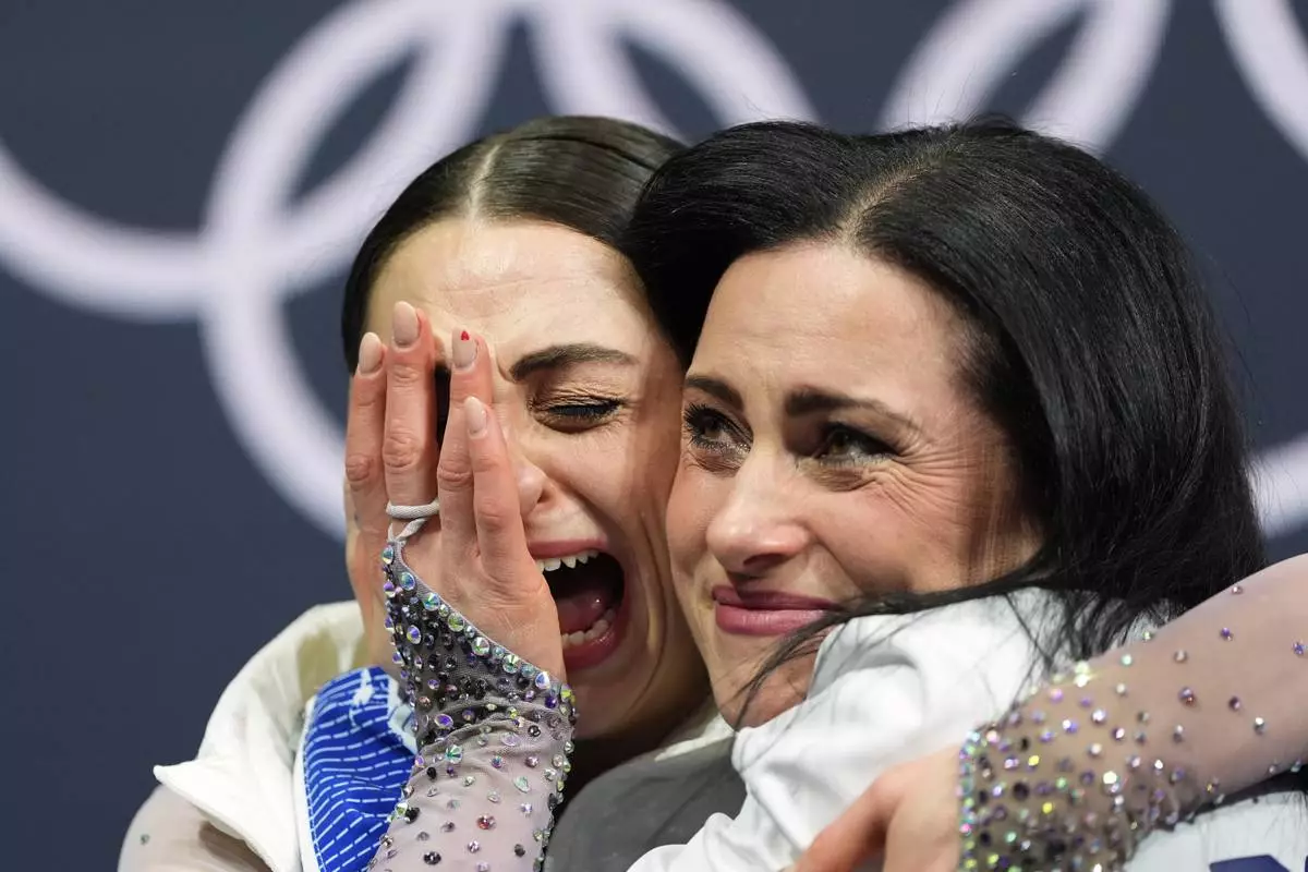 Julia Sauter of Romania reacts to her score after competing in the women's figure skating free program at the 2026 Winter Olympics, in Milan, Italy, Thursday, Feb. 19, 2026. (AP Photo/Stephanie Scarbrough)