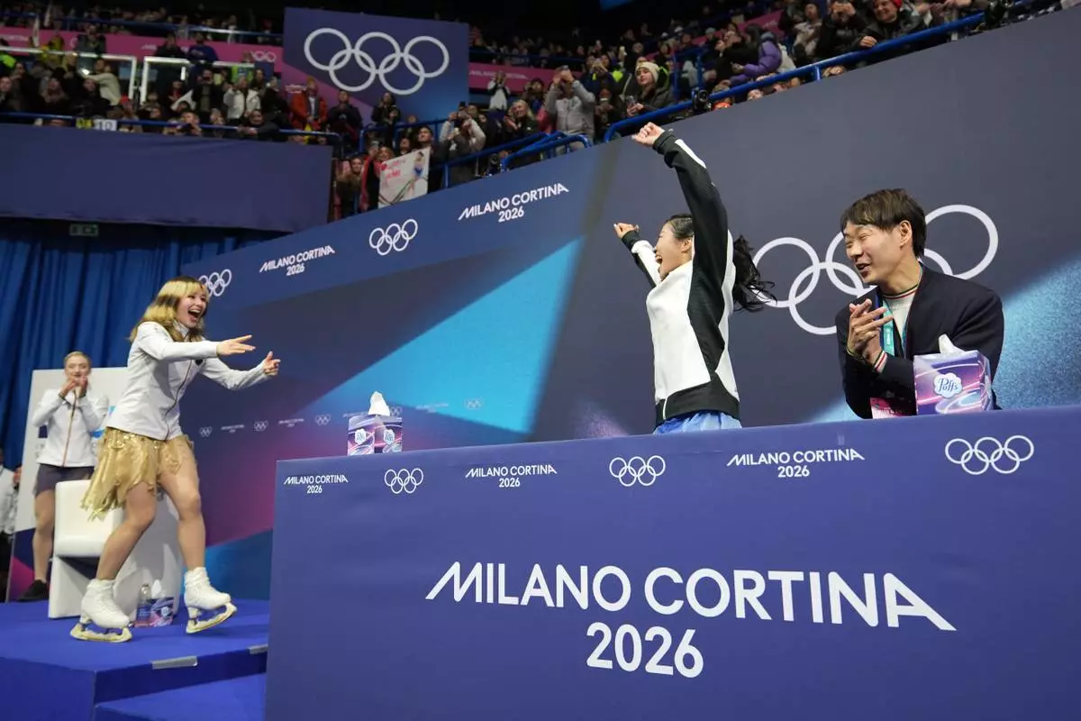 Ami Nakai of Japan reacts to her score that won her a bronze as Alysa Liu of the United States realizes she won the gold after competing in the women's figure skating free program at the 2026 Winter Olympics, in Milan, Italy, Thursday, Feb. 19, 2026. (AP Photo/Stephanie Scarbrough)