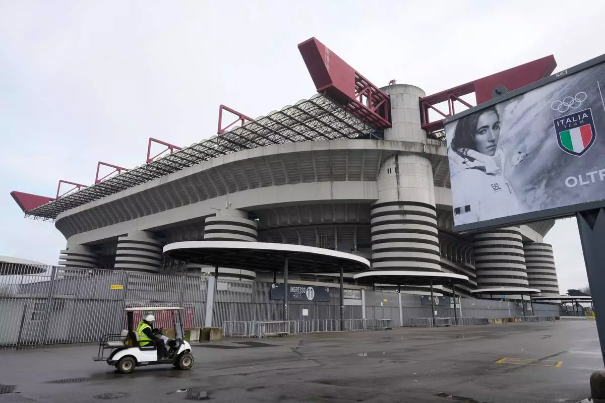 Workers drive a golf buggy outside a compound next to the San Siro Stadium during rehearsals for the opening ceremony of the Milan Cortina 2026 Winter Olympic Games, at , in Milan, Italy, Saturday, Jan. 24, 2026. (AP Photo/Luca Bruno)