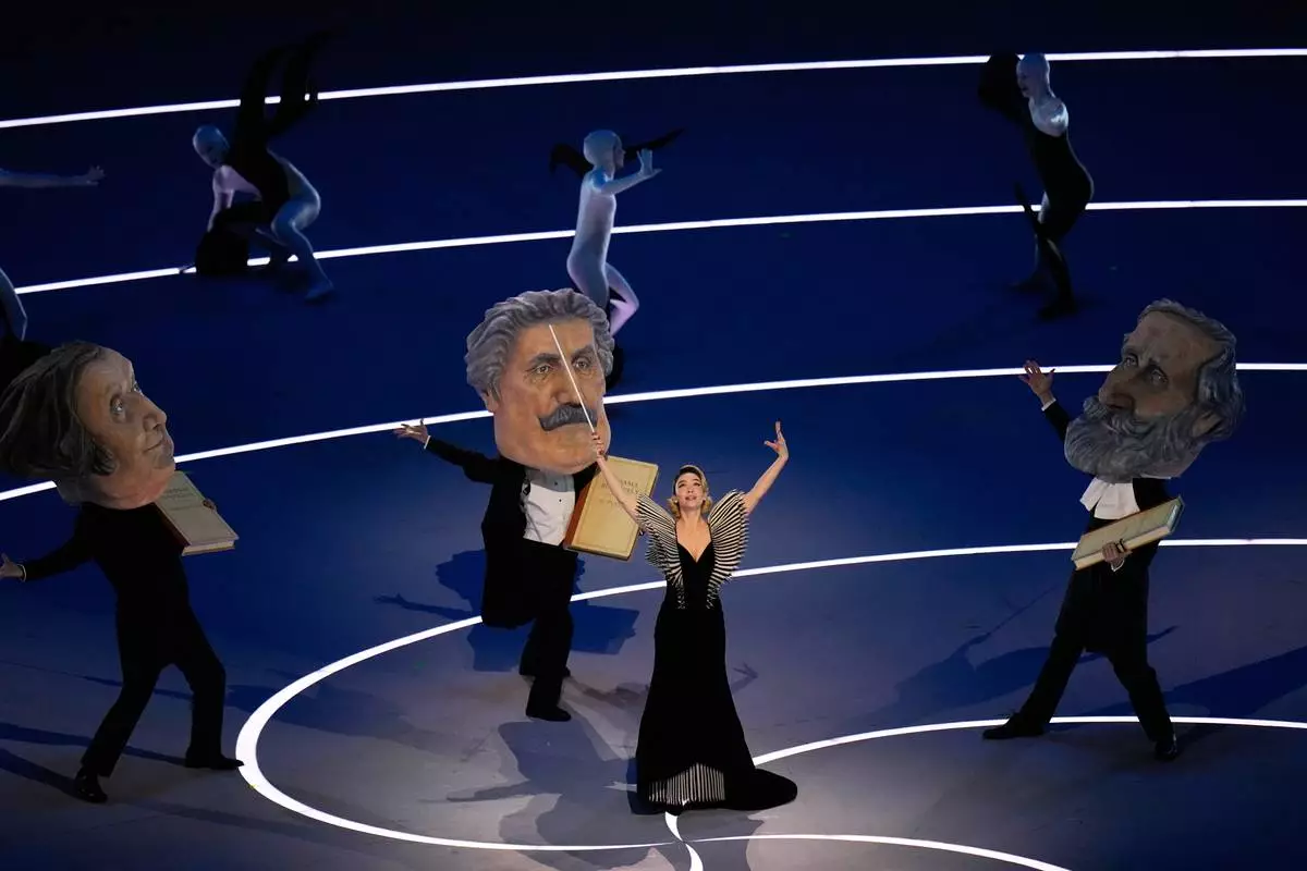 Italian actor Matilda De Angelis, left, performs during the Olympic opening ceremony at the 2026 Winter Olympics, in Milan, Italy, Friday, Feb. 6, 2026. (AP Photo/Hassan Ammar)