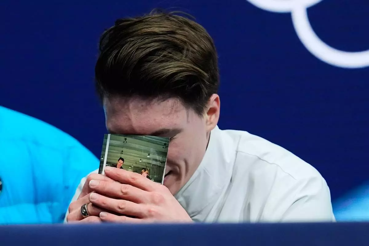 Maxim Naumov of the United States reacts to his scores after competing during the men's free skate program in figure skating at the 2026 Winter Olympics, in Milan, Italy, Friday, Feb. 13, 2026. (AP Photo/Francisco Seco)