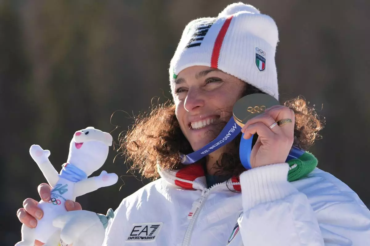 Italy's Federica Brignone shows her gold medal in an alpine ski, women's giant slalom race, at the 2026 Winter Olympics, in Cortina d'Ampezzo, Italy, Sunday, Feb. 15, 2026. (AP Photo/Jacquelyn Martin)