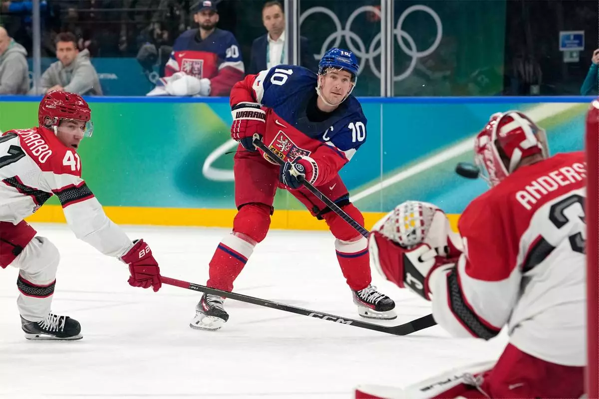 Czechia's Roman Cervenka (10) scores a goal against Denmark goalkeeper Frederik Andersen (31) during the second period of a men's ice hockey qualification playoff game at the 2026 Winter Olympics, in Milan, Italy, Tuesday, Feb. 17, 2026. (AP Photo/Hassan Ammar)