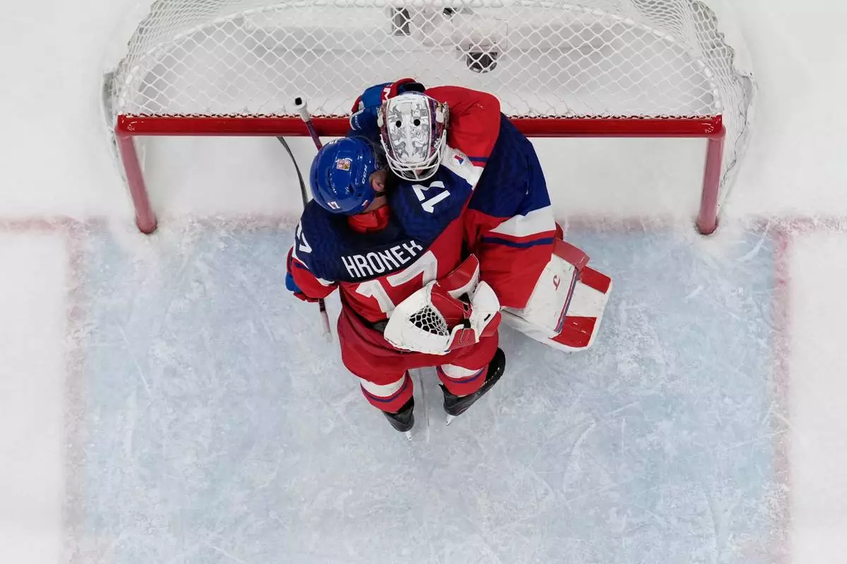 Czechia's Lukas Dostal (1) and Czechia's Filip Hronek (17) embrace after winning a men's ice hockey qualification playoff game between Czechia and Denmark at the 2026 Winter Olympics, in Milan, Italy, Tuesday, Feb. 17, 2026. (AP Photo/Carolyn Kaster)