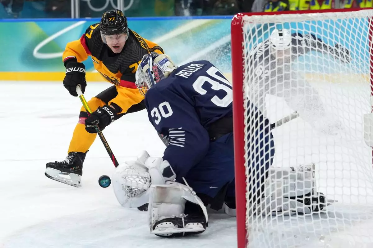 Germany's John Peterka (77) shoots against France goalkeeper Antoine Keller (30) during the second period of a men's ice hockey qualification playoff game at the 2026 Winter Olympics, in Milan, Italy, Tuesday, Feb. 17, 2026. (AP Photo/Carolyn Kaster)