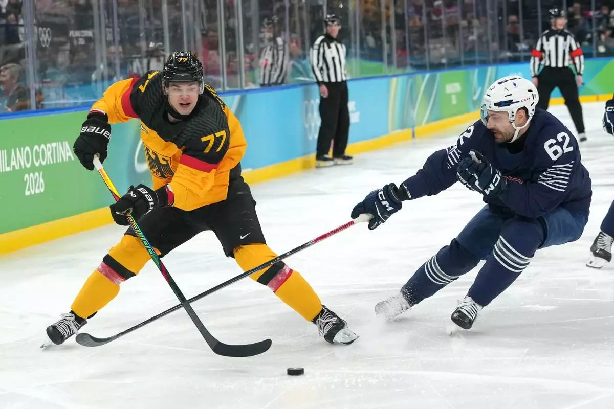 Germany's John Peterka (77) moves the puck against France's Florian Chakiachvili (62) during the second period of a men's ice hockey qualification playoff game at the 2026 Winter Olympics, in Milan, Italy, Tuesday, Feb. 17, 2026. (AP Photo/Carolyn Kaster)