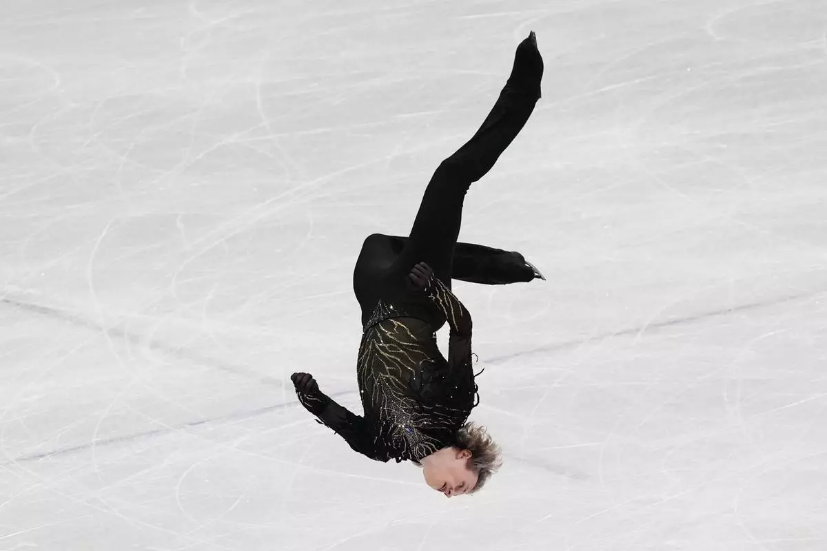 Ilia Malinin of the United States does a back flip while competing during the men's free skate program in figure skating at the 2026 Winter Olympics, in Milan, Italy, Friday, Feb. 13, 2026. (AP Photo/Stephanie Scarbrough)