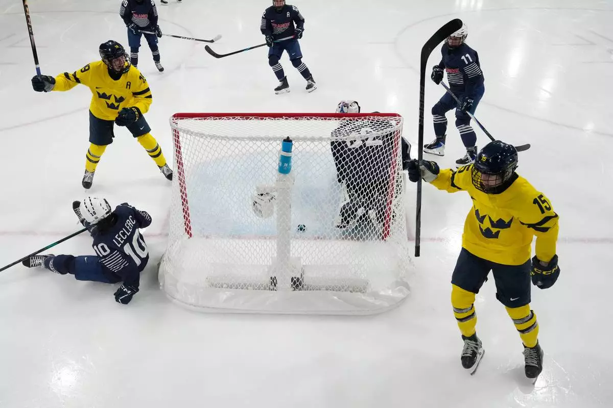 Sweden's Lisa Johansson, right, celebrates after scoring her side's fourth goal during a preliminary round match of women's ice hockey between France and Sweden at the 2026 Winter Olympics, in Milan, Italy, Sunday, Feb. 8, 2026. (AP Photo/Darko Bandic, Pool)