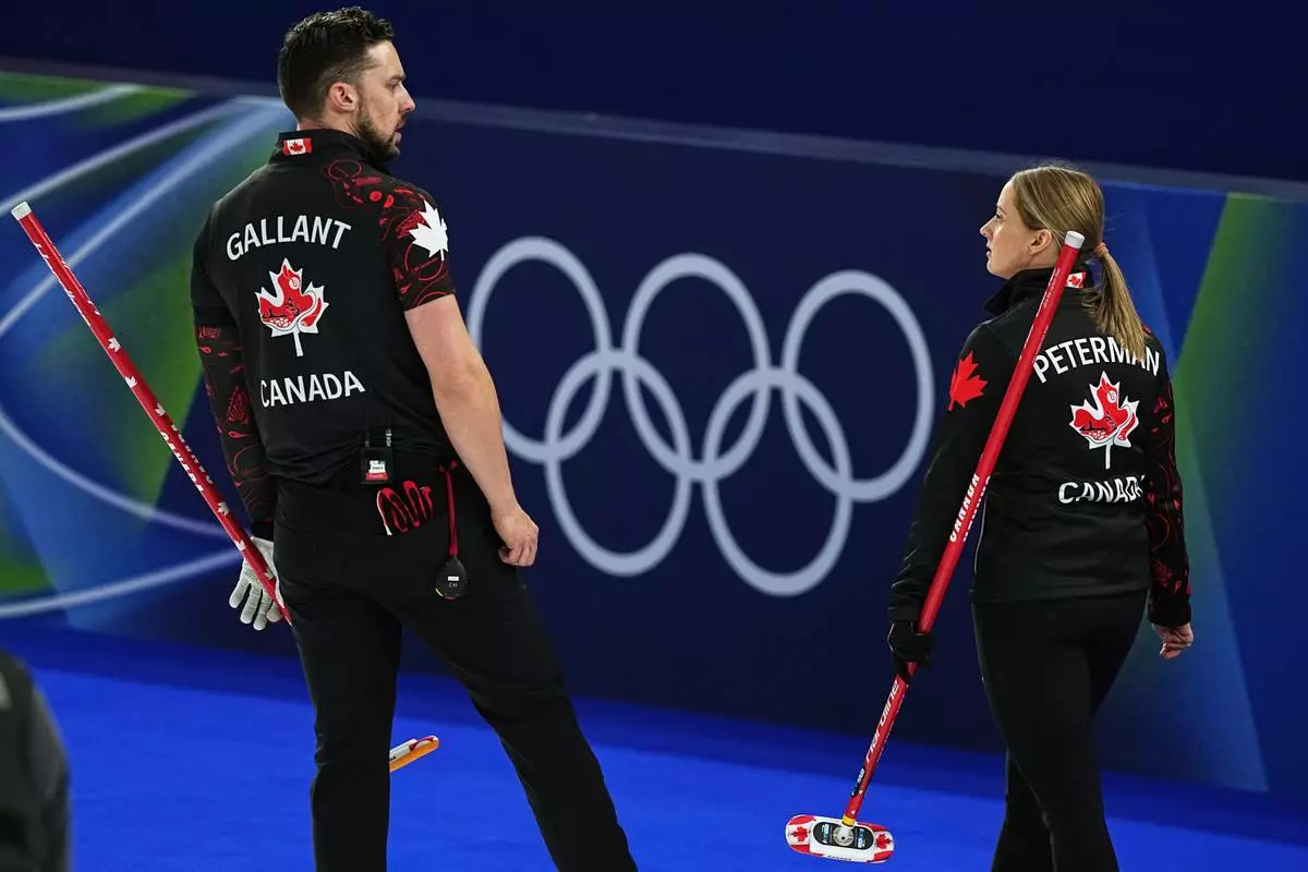 Canada's Brett Gallant and Jocelyn Peterman in action during the mixed doubles round robin phase of the curling competition against Sweden, at the 2026 Winter Olympics, in Cortina d'Ampezzo, Italy, Sunday, Feb. 8, 2026. (AP Photo/Fatima Shbair)