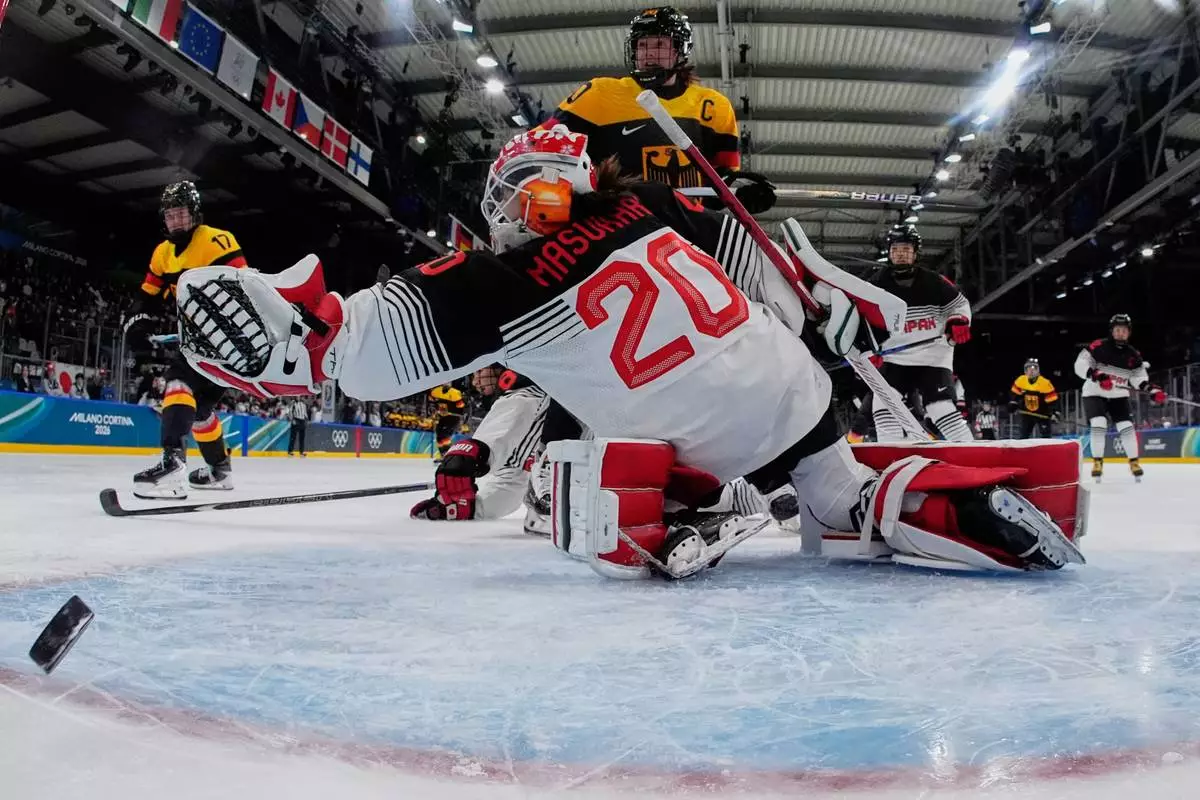 Germany's Emily Nix scores her side's third goal during a preliminary round match of women's ice hockey between Germany and Japan at the 2026 Winter Olympics, in Milan, Italy, Saturday, Feb. 7, 2026. (AP Photo/Darko Bandic, Pool)