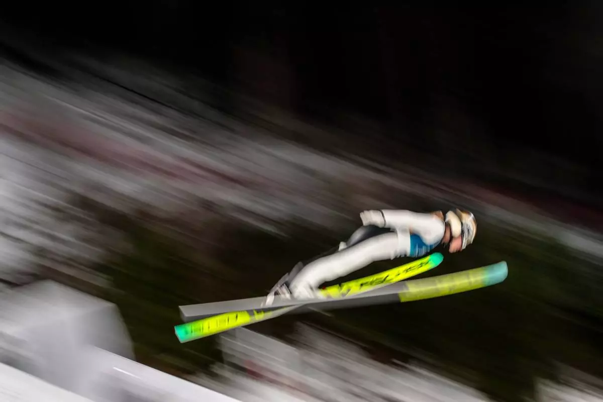 Meghann Wadsak, of Austria, soars through the air during her first round jump of the ski jumping women's normal hill individual, at the 2026 Winter Olympics, in Predazzo, Italy, Saturday, Feb. 7, 2026. (AP Photo/Evgeniy Maloletka)