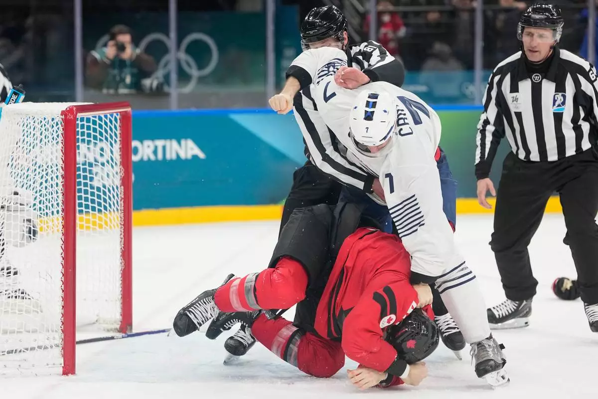 France's Pierre Crinon (7) and Canada's Tom Wilson (43) fight in the third period during a preliminary round game of men's ice hockey between Canada and France at the 2026 Winter Olympics, in Milan, Italy, Sunday, Feb. 15, 2026. (AP Photo/Hassan Ammar)