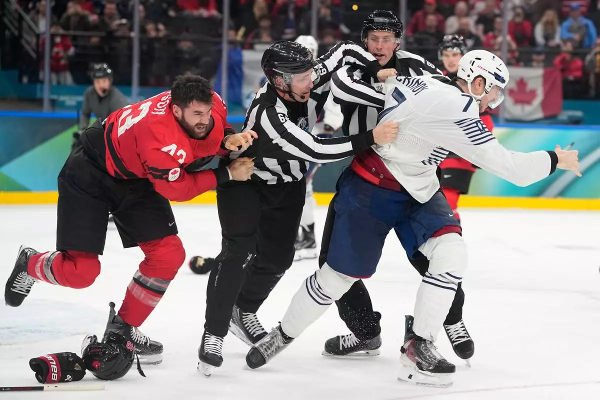 France's Pierre Crinon (7) and Canada's Tom Wilson (43) fight in the third period during a preliminary round game of men's ice hockey between Canada and France at the 2026 Winter Olympics, in Milan, Italy, Sunday, Feb. 15, 2026. (AP Photo/Hassan Ammar)