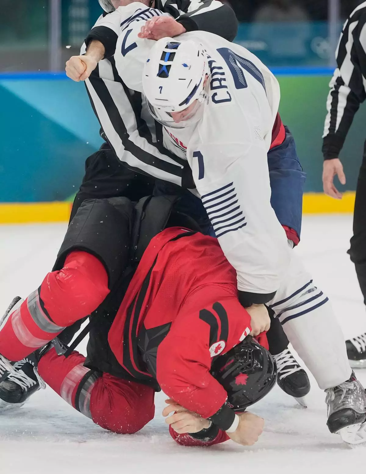 France's Pierre Crinon (7) and Canada's Tom Wilson (43) fight in the third period during a preliminary round game of men's ice hockey between Canada and France at the 2026 Winter Olympics, in Milan, Italy, Sunday, Feb. 15, 2026. (AP Photo/Hassan Ammar)