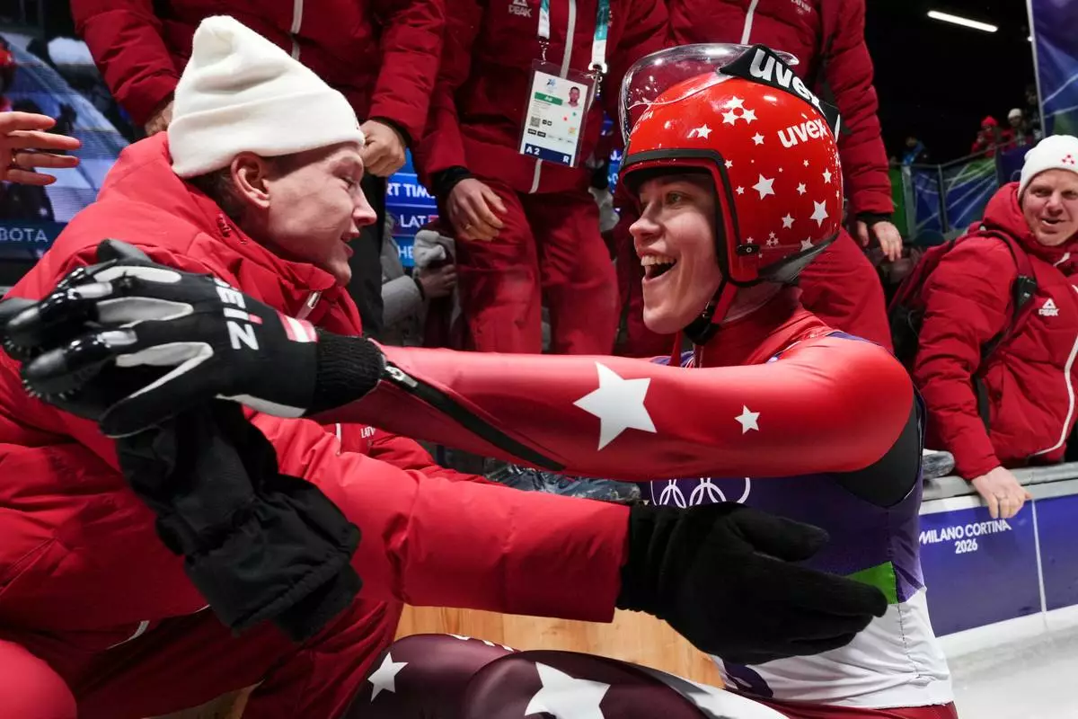 Latvia's Elina Bote celebrates winning the silver medal during the women's single luge competition at the 2026 Winter Olympics, in Cortina d'Ampezzo, Italy, Tuesday, Feb. 10, 2026. (AP Photo/Alessandra Tarantino)