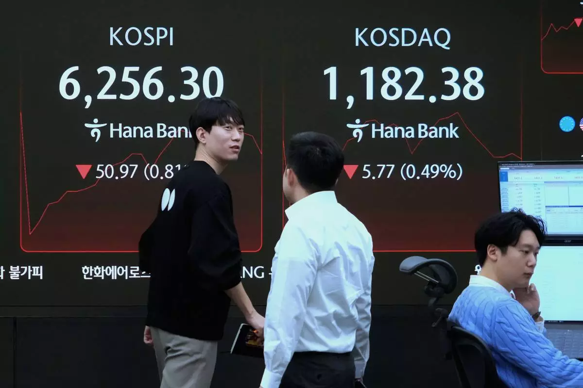 A currency trader passes by a screen showing the Korea Composite Stock Price Index (KOSPI), left, at the foreign exchange dealing room of the Hana Bank headquarters in Seoul, South Korea, Friday, Feb. 27, 2026. (AP Photo/Ahn Young-joon)