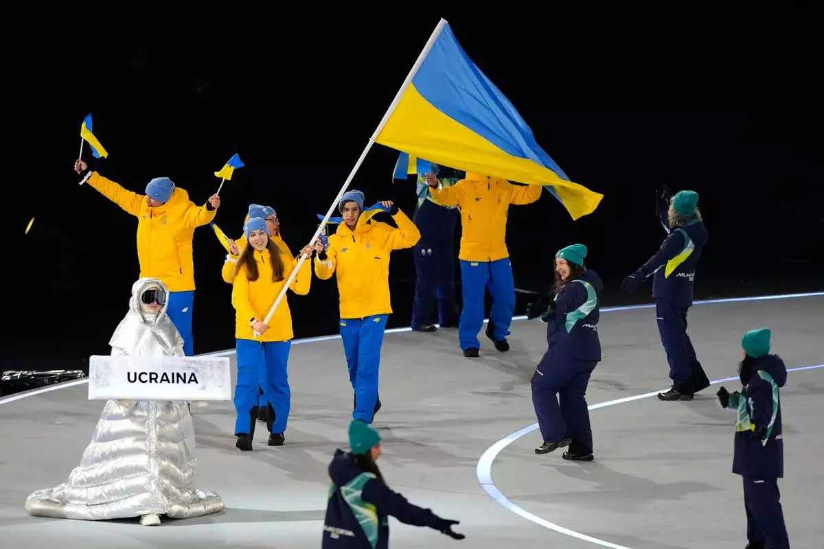Yelyzaveta Sydorko, flag bearer of Ukraine, leads Ukrainian athletes during the Olympic opening ceremony at the 2026 Winter Olympics, in Milan, Italy, Friday, Feb. 6, 2026. (AP Photo/Lee Jin-man)