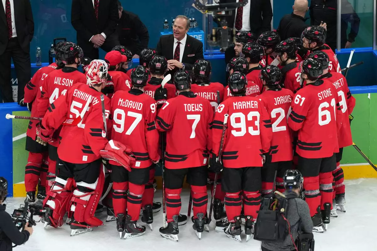 Canada head coach Jon Cooper talks with his players after their win against Finland in a men's ice hockey semifinal game at the 2026 Winter Olympics in Milan, Italy, Friday, Feb. 20, 2026. (AP Photo/Carolyn Kaster)