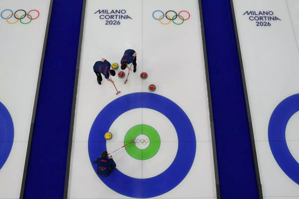 Britain's Bruce Mouat, Grant Hardie and Hammy McMillan compete during a men's curling semifinal match against Switzerland at the 2026 Winter Olympics, in Cortina d'Ampezzo, Italy, Thursday, Feb. 19, 2026. (AP Photo/David J. Phillip)