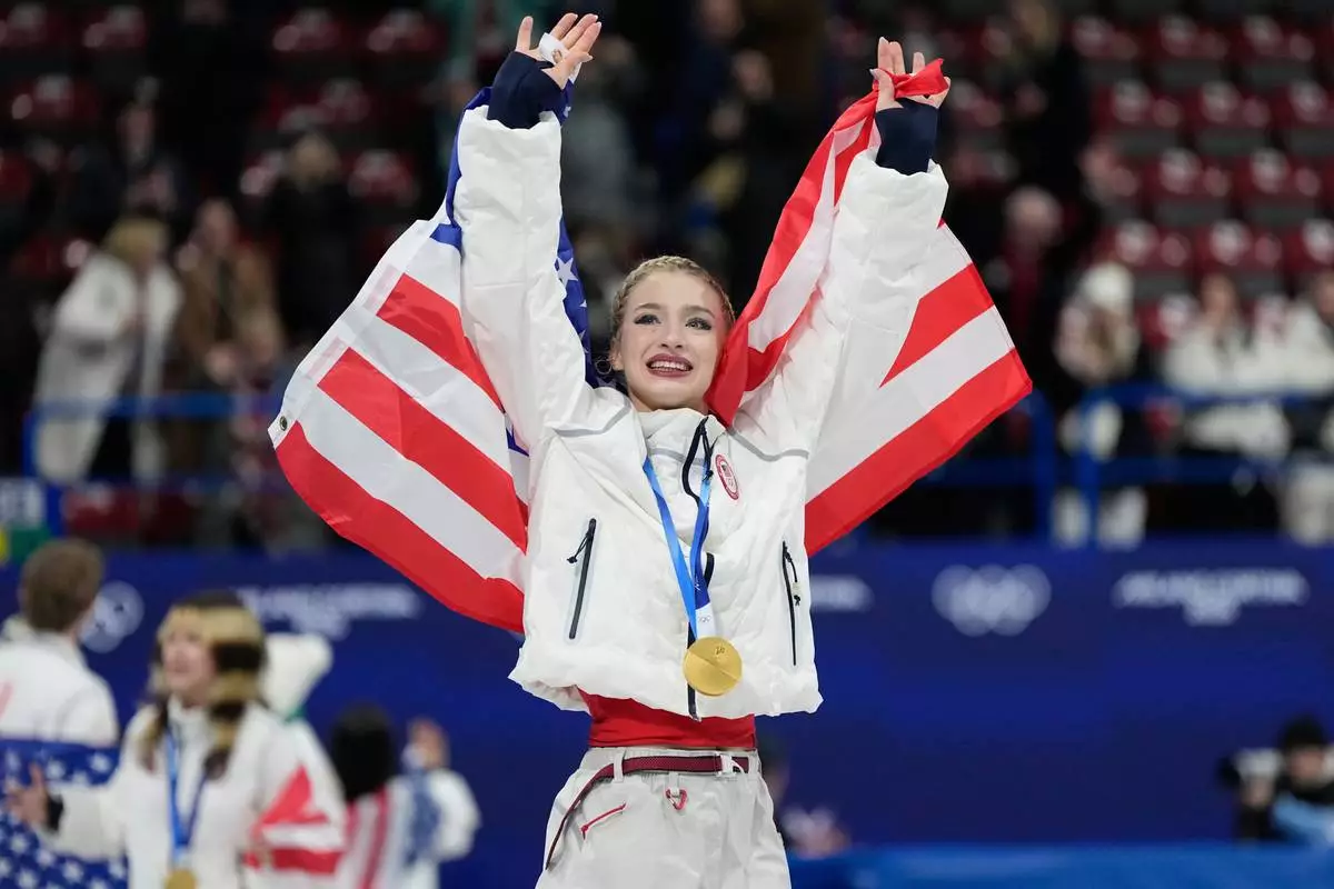 Team USA's Amber Glenn celebrates with her gold medal after the figure skating team event at the 2026 Winter Olympics, in Milan, Italy, Sunday, Feb. 8, 2026. (AP Photo/Ashley Landis)
